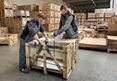 Dwóch pracowników pakuje skrzynię z kamieniami