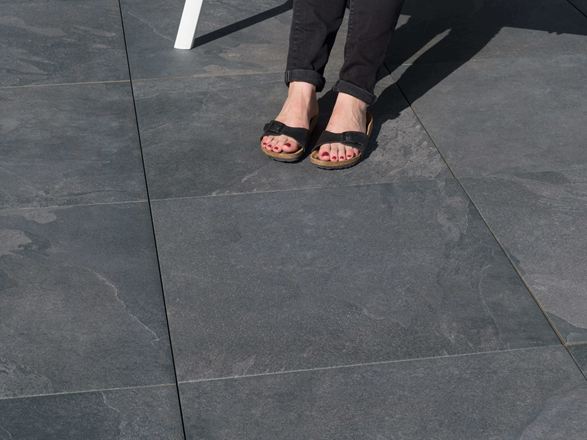 Stopy na płytkach tarasowych z gresu porcelanowego Alpine Black