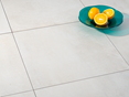 Płytki z gresu porcelanowego Pure Sand w jasnym stylu betonowym z dwiema miskami dekoracyjnymi i białym obrusem