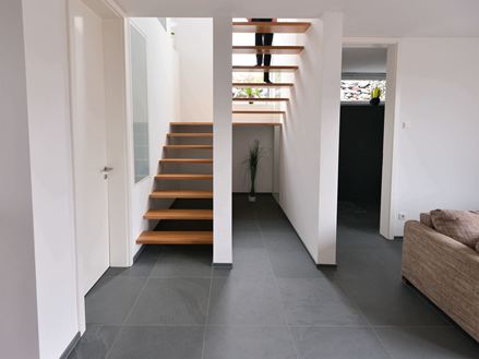 Płytki łupkowe Grey Slate ułożone w przestronnym salonie z klatką schodową