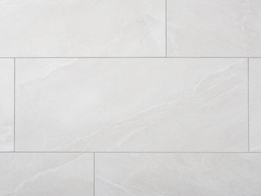 Zbliżenie na jasnoszare płytki z gresu porcelanowego imitujące łupek, z wąskimi fugami