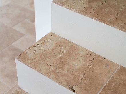 Stopnie schodów wyłożone płytkami z trawertynu w odcieniu Medium
