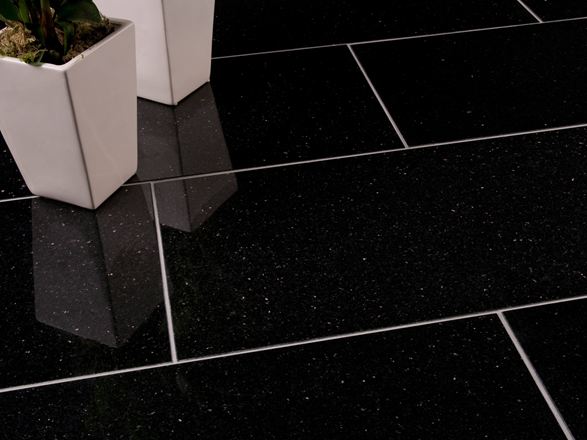 Dwie białe donice na ciemnych płytkach granitowych Star Galaxy z wąskimi jasnymi fugami