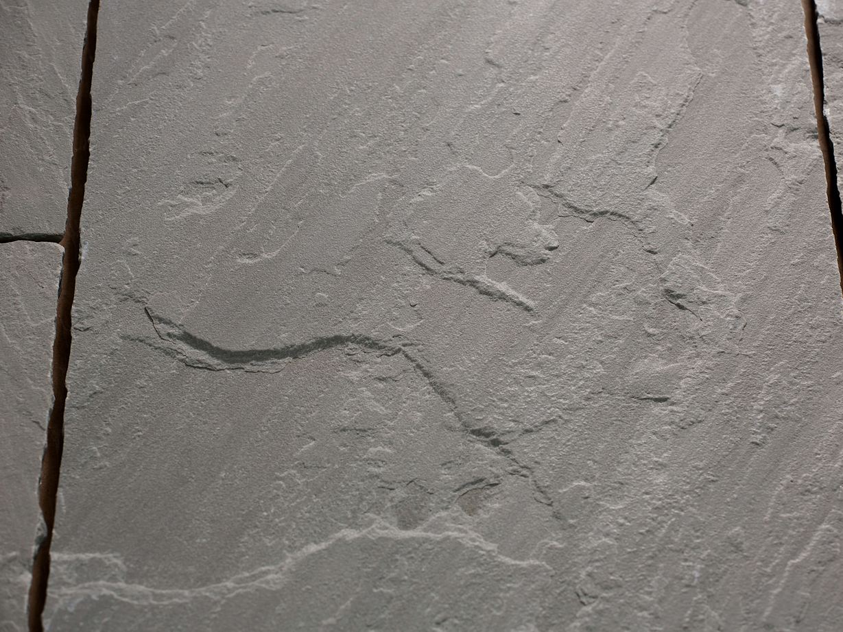 Zbliżenie na płytę z piaskowca Kandla Grey o naturalnie aksamitnej, szczotkowanej powierzchni