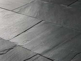 Zbliżenie na ułożoną płytę łupkową Black Rustic o powierzchni ciosanej