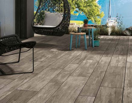 Taras wyłożony płytkami z gresu porcelanowego w ciemnym wzorze imitującym drewno