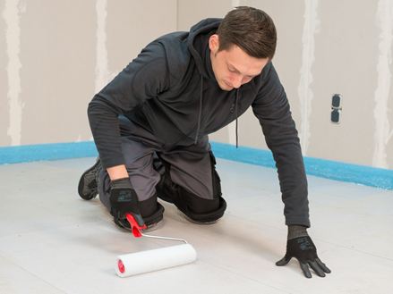 Układacz płytek nakłada podkład za pomocą wałka